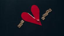 Wycięte z papieru czerwone serce przedarte na pół. Obok ułożony z drewnianych liter napis "Not Yours".